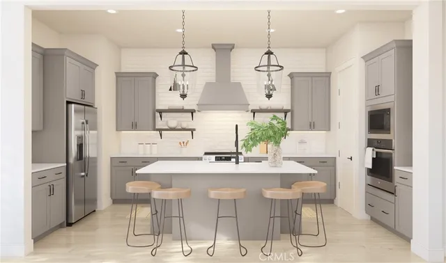 a kitchen with stainless steel appliances kitchen island granite countertop a dining table chairs and white cabinets