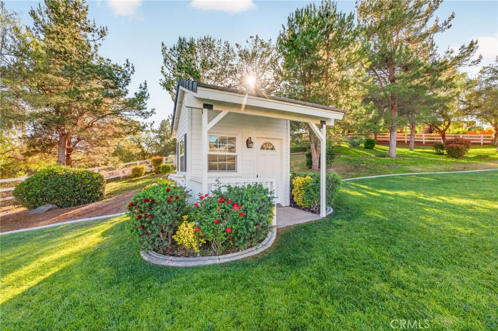 41515 Vía Del Monte Temecula, CA 92592 - Photo 53 of 64 a view of a white house with a big yard and potted plants and large trees