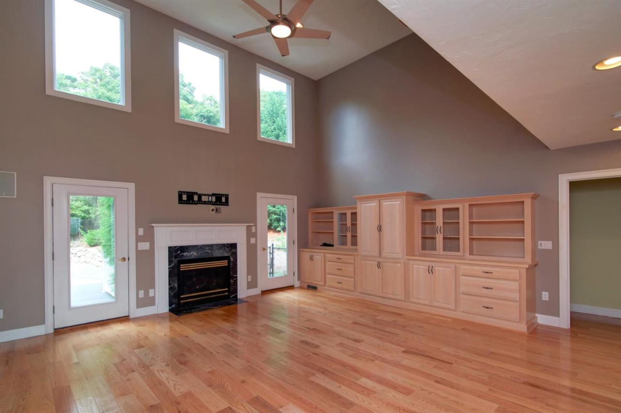 153 Cairn Ridge Road East Falmouth, MA 02536 - Photo 15 of 25 an empty room with windows fireplace and wooden floor