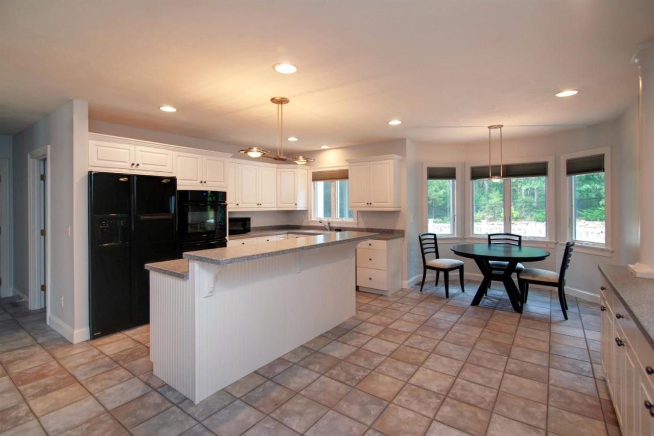 153 Cairn Ridge Road East Falmouth, MA 02536 - Photo 8 of 25 a kitchen with stainless steel appliances kitchen island granite countertop a refrigerator a sink a dining table and chairs