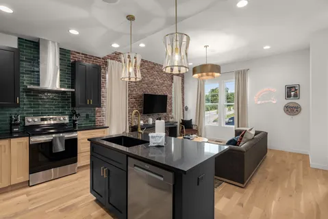 a kitchen with stainless steel appliances granite countertop a refrigerator a sink and wooden cabinets