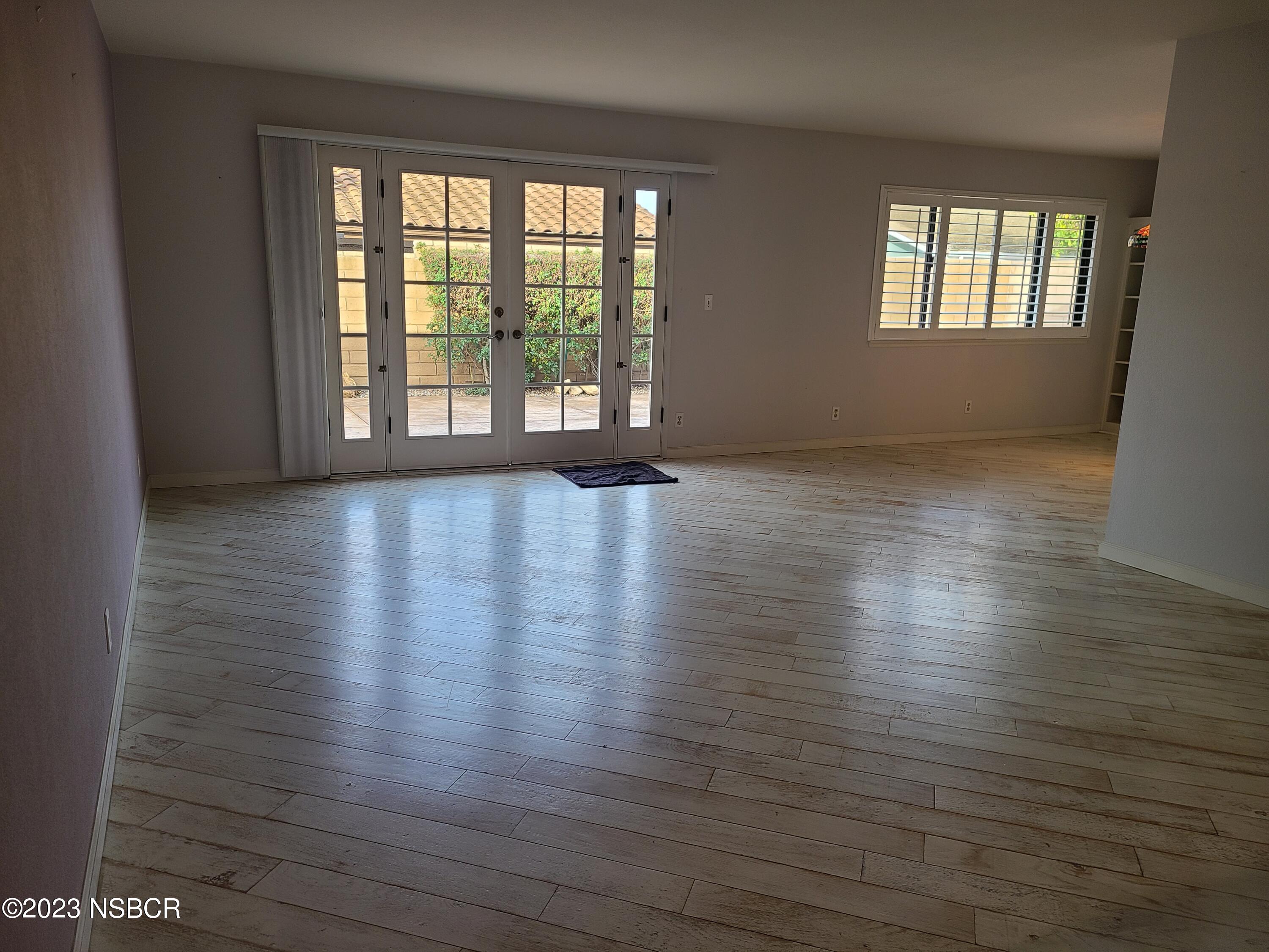 1205 North B Street Lompoc, CA 93436 - Photo 11 of 39 an empty room with wooden floor and windows