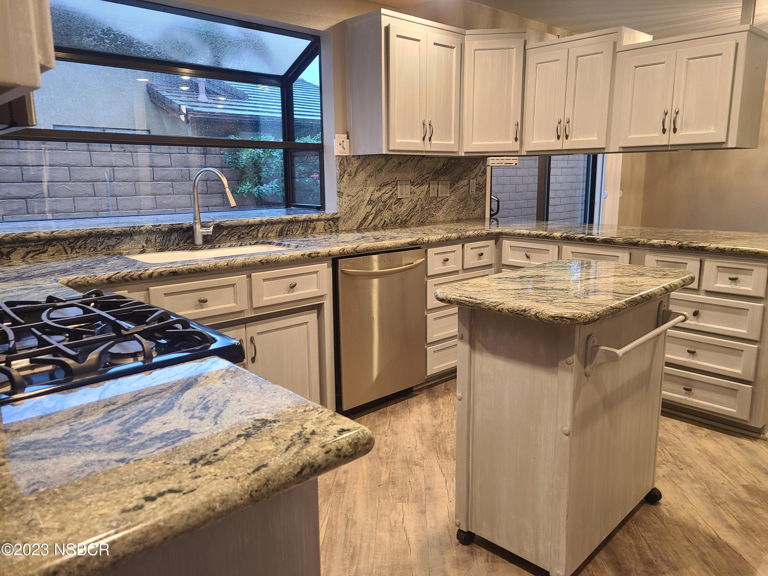 1205 North B Street Lompoc, CA 93436 - Photo 14 of 39 a kitchen with stainless steel appliances granite countertop a stove a sink and a microwave