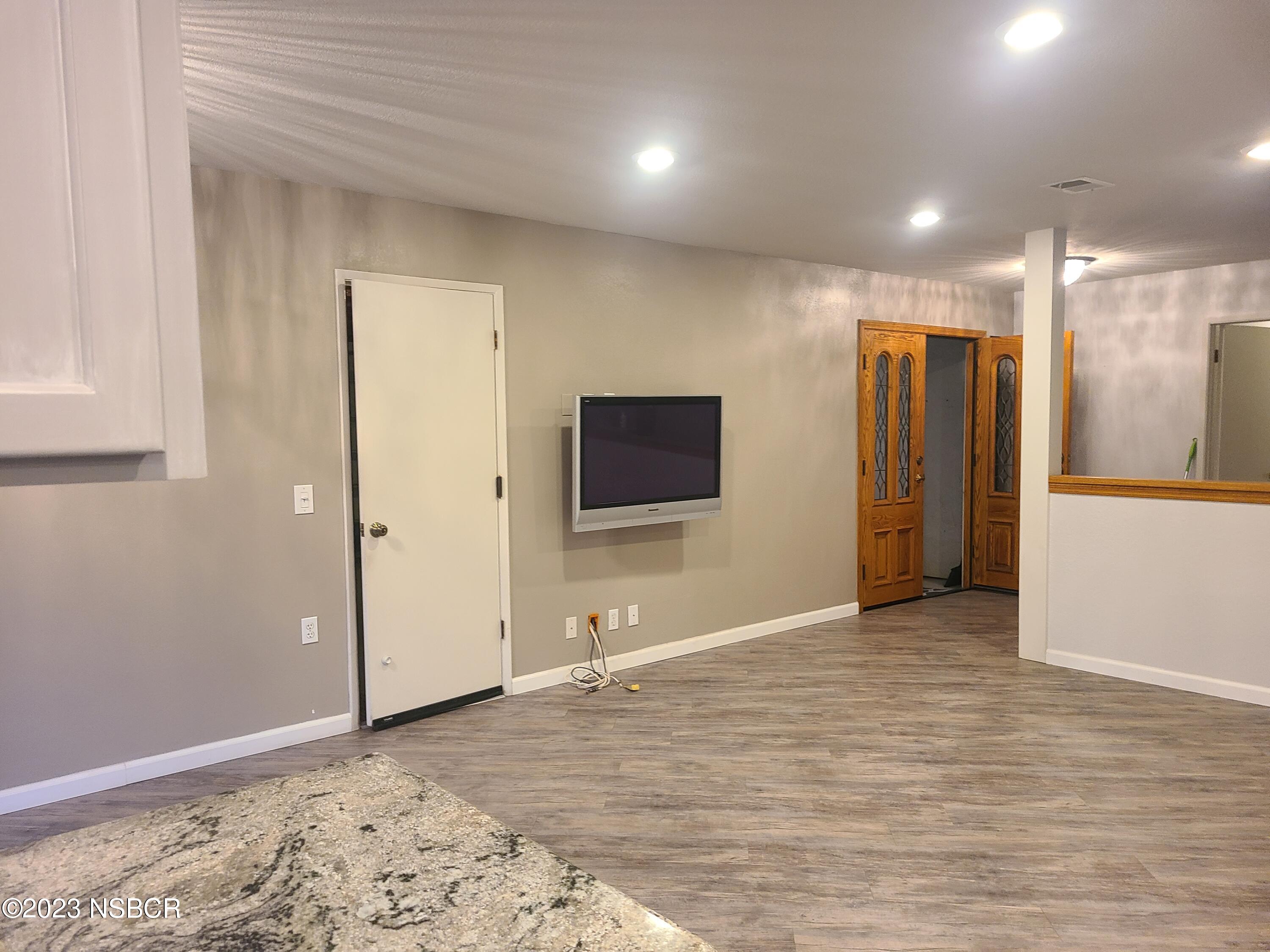 1205 North B Street Lompoc, CA 93436 - Photo 18 of 39 a view of a livingroom with wooden floor and kitchen space