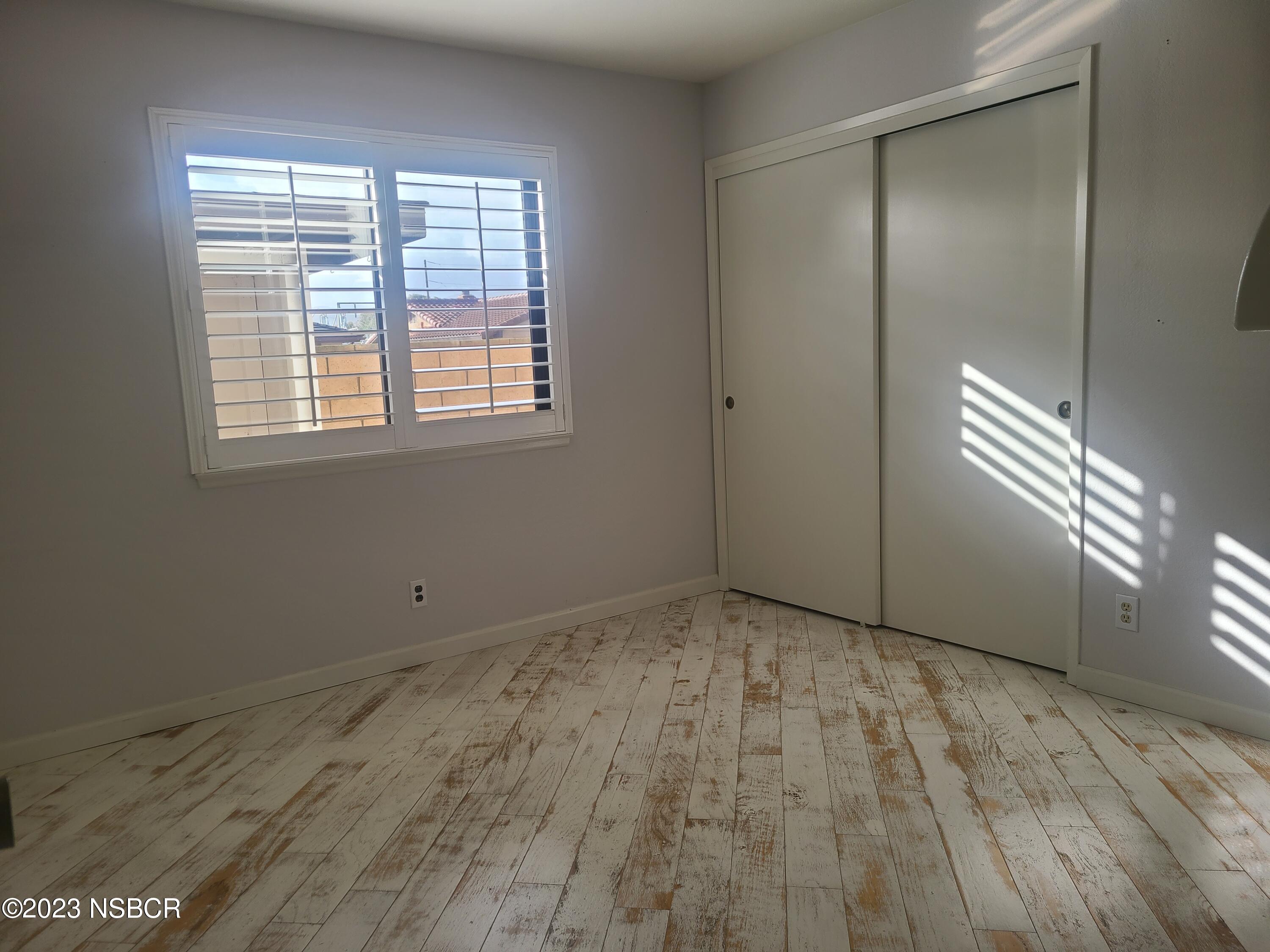 1205 North B Street Lompoc, CA 93436 - Photo 23 of 39 a view of an empty room with wooden floor and a window