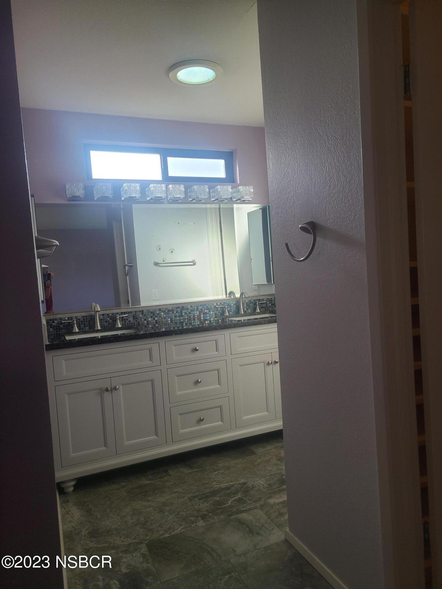 1205 North B Street Lompoc, CA 93436 - Photo 27 of 39 a bathroom with a granite countertop sink and a mirror