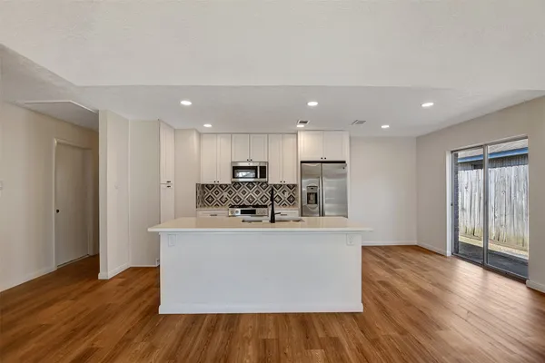 a kitchen with a sink cabinets and wooden floor