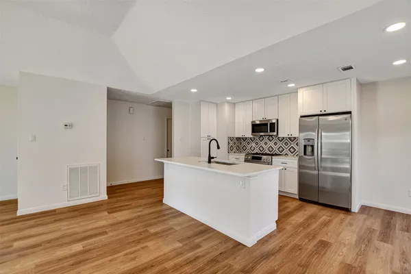 a kitchen with refrigerator cabinets and furniture
