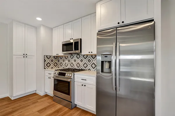 a view of a room with a flat screen tv and a ceiling fan