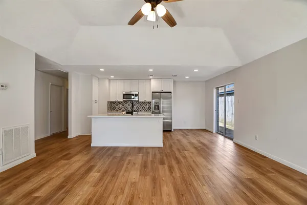 a view of empty room with wooden floor and fireplace