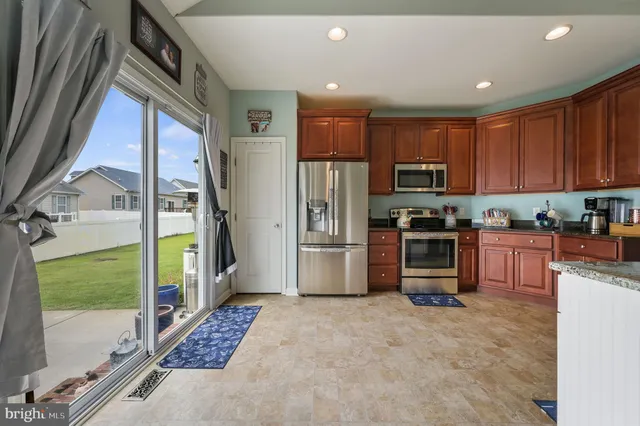 a kitchen with stainless steel appliances granite countertop a refrigerator and a stove