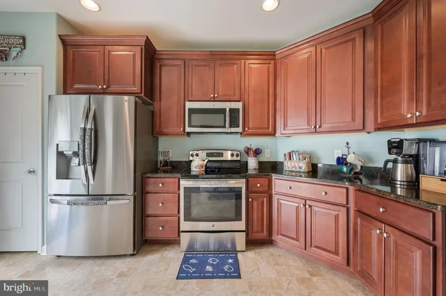 a kitchen with granite countertop wooden cabinets and stainless steel appliances
