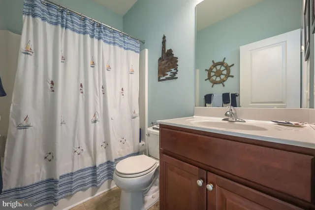 a bathroom with a sink a toilet and shower curtain