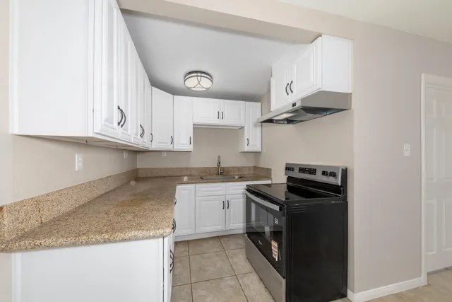 a kitchen with stainless steel appliances granite countertop a sink and a stove