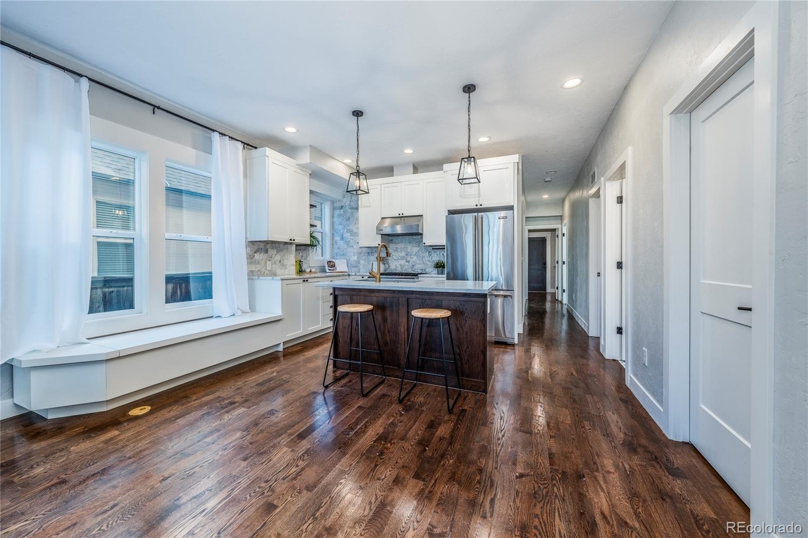1367 Monroe Street Denver, CO 80206 - Photo 12 of 48 a large kitchen with a wooden floor and stainless steel appliances