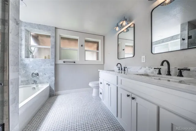 a spacious bathroom with a double vanity sink mirror and bathtub