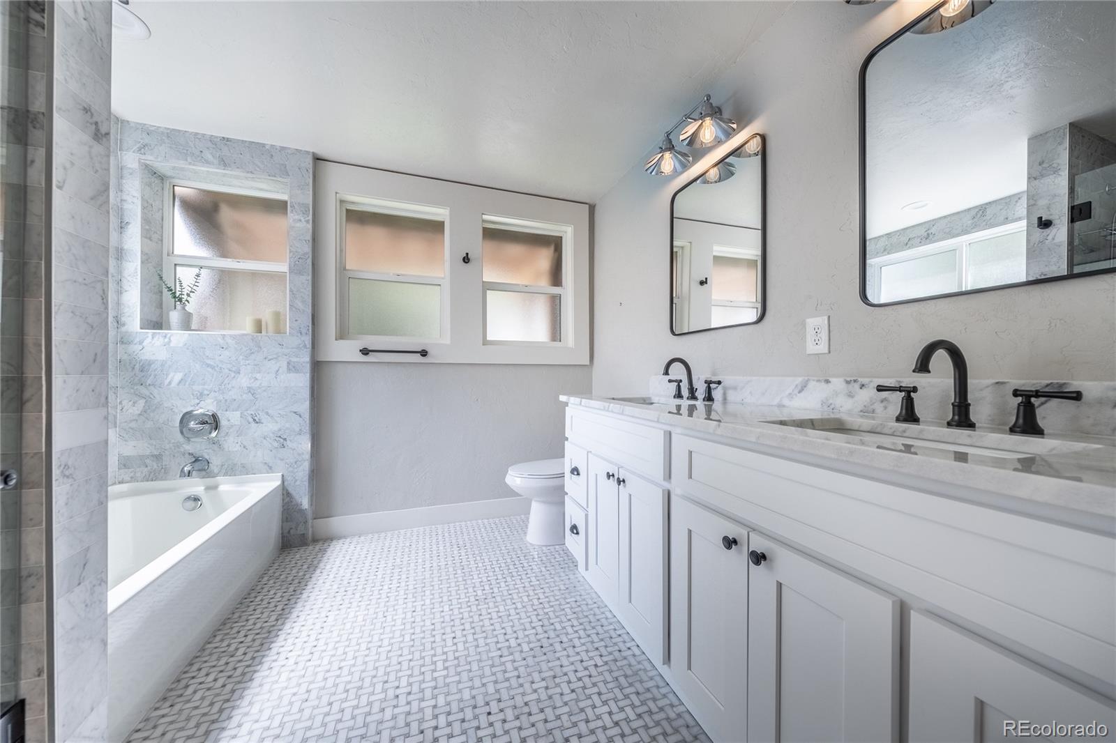1367 Monroe Street Denver, CO 80206 - Photo 15 of 48 a spacious bathroom with a double vanity sink mirror and bathtub