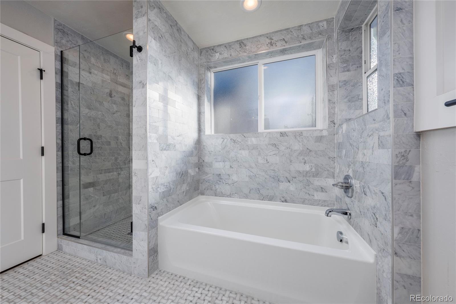 1367 Monroe Street Denver, CO 80206 - Photo 16 of 48 a bathroom with a bathtub and a shower