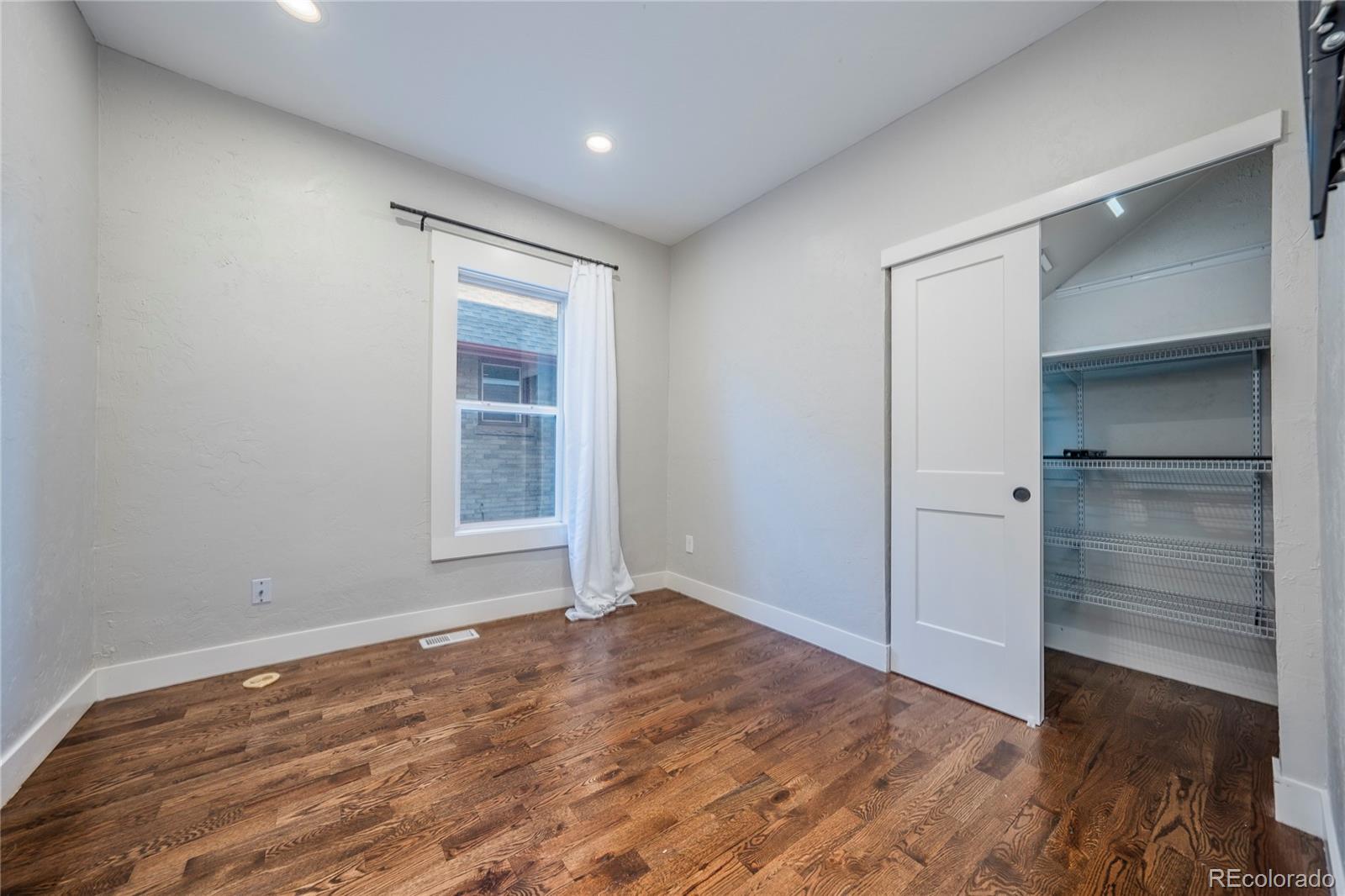1367 Monroe Street Denver, CO 80206 - Photo 21 of 48 wooden floor in an empty room with a window