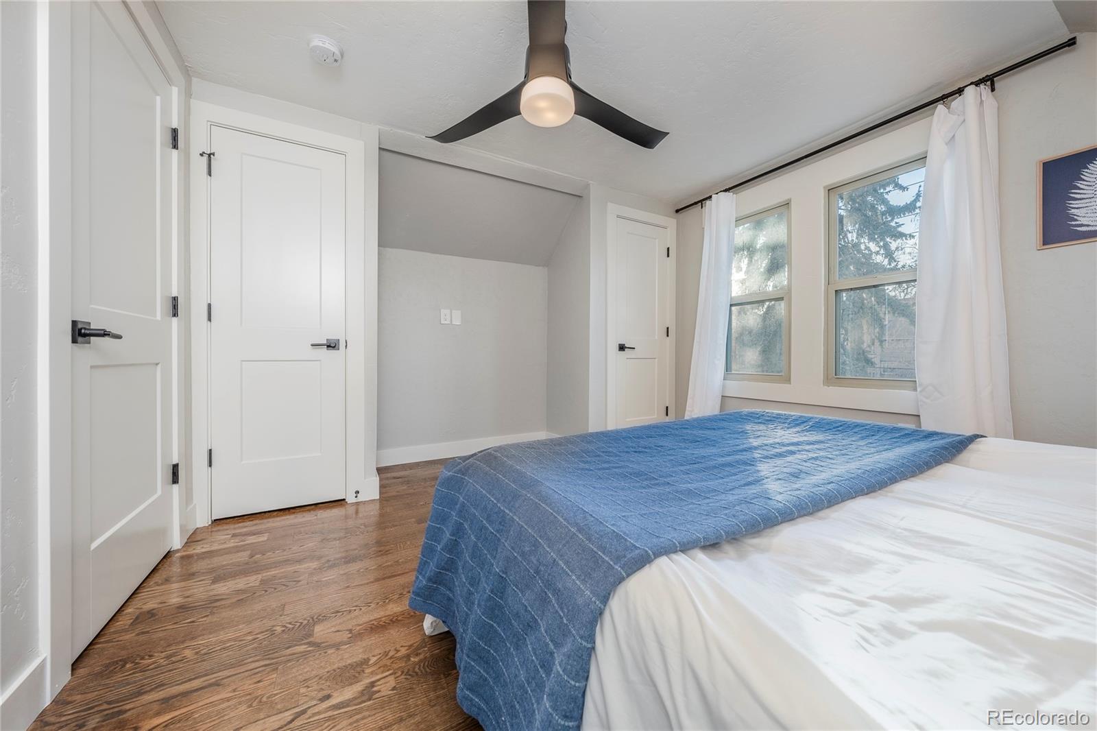 1367 Monroe Street Denver, CO 80206 - Photo 25 of 48 a bedroom with a bed and a chandelier