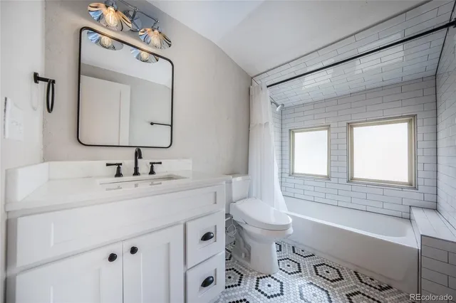 a bathroom with a sink vanity granite toilet tub and shower