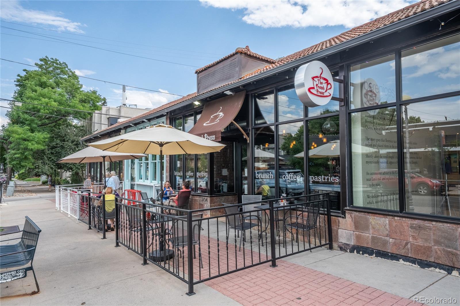 1367 Monroe Street Denver, CO 80206 - Photo 46 of 48 a view of a cafe with a couple of people seating under an umbrella