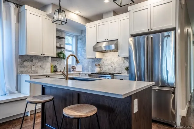 a kitchen with stainless steel appliances a sink stove and refrigerator