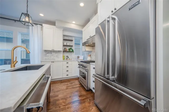 a kitchen with kitchen island a counter top space stainless steel appliances and cabinets