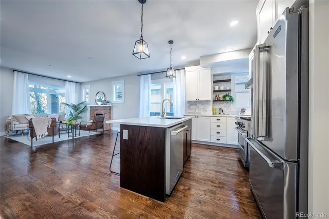 a kitchen with kitchen island a counter top space a sink stainless steel appliances and cabinets