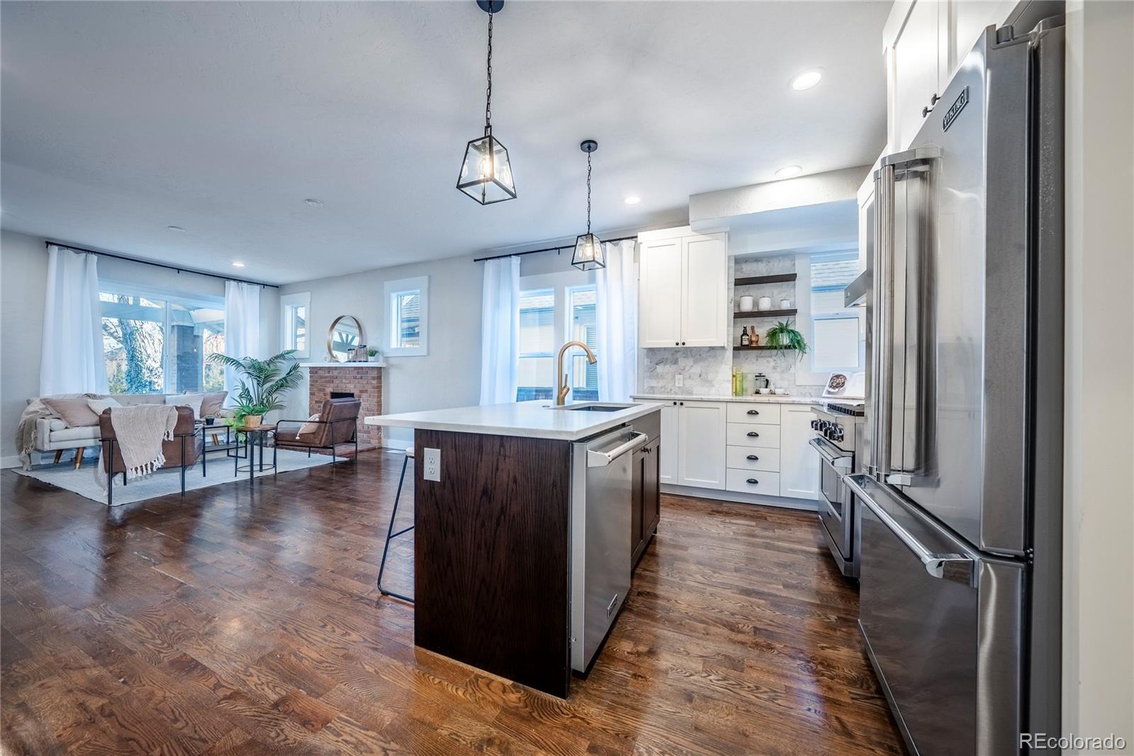 1367 Monroe Street Denver, CO 80206 - Photo 10 of 48 a kitchen with kitchen island a counter top space a sink stainless steel appliances and cabinets