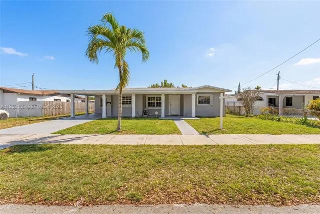 a view of house with swimming pool and yard