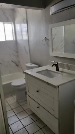 a bathroom with a sink a toilet and mirror