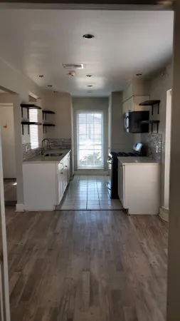 a view of a kitchen with a sink dishwasher and fireplace