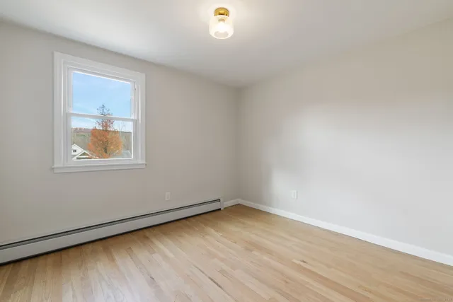 wooden floor in an empty room with a window
