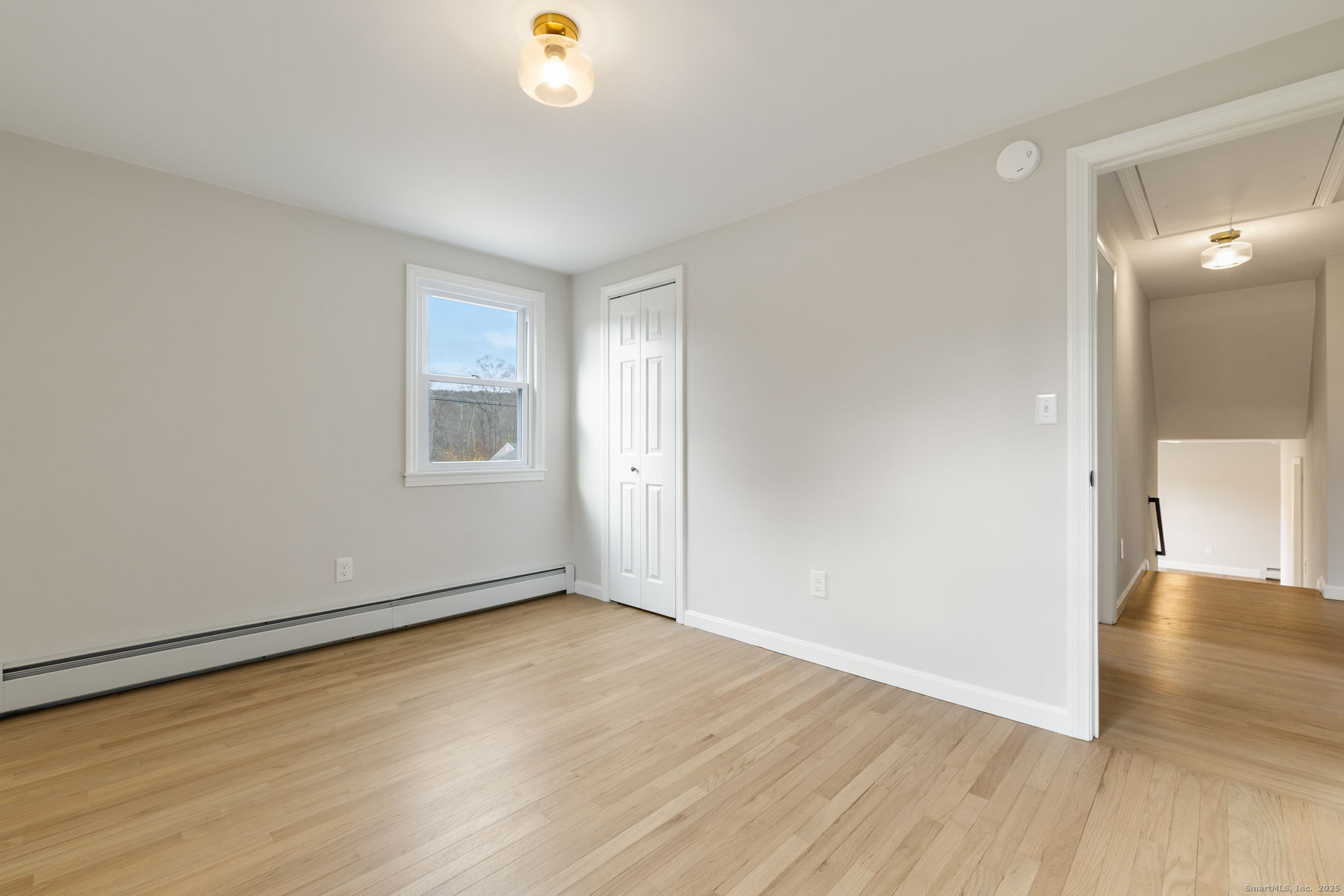 410 South Stone Street Suffield, CT 06093 - Photo 19 of 23 an empty room with wooden floor and windows