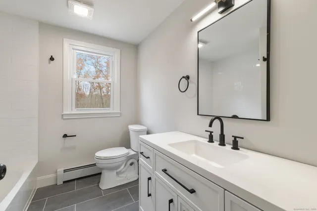 a bathroom with a toilet sink and mirror