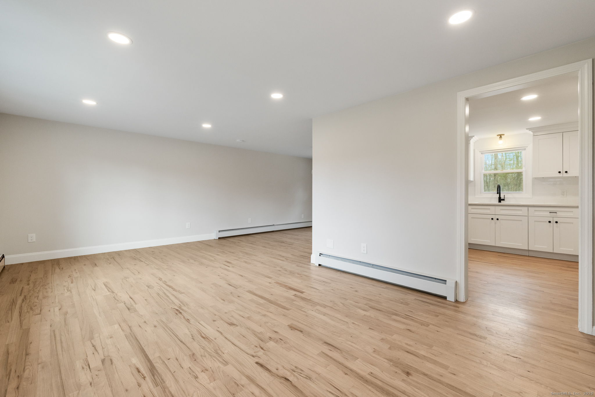 410 South Stone Street Suffield, CT 06093 - Photo 2 of 23 an empty room with wooden floor and windows