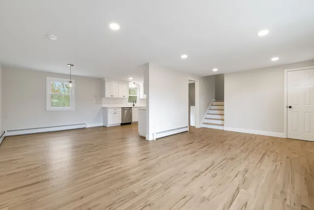 a view of empty room with wooden floor and windows