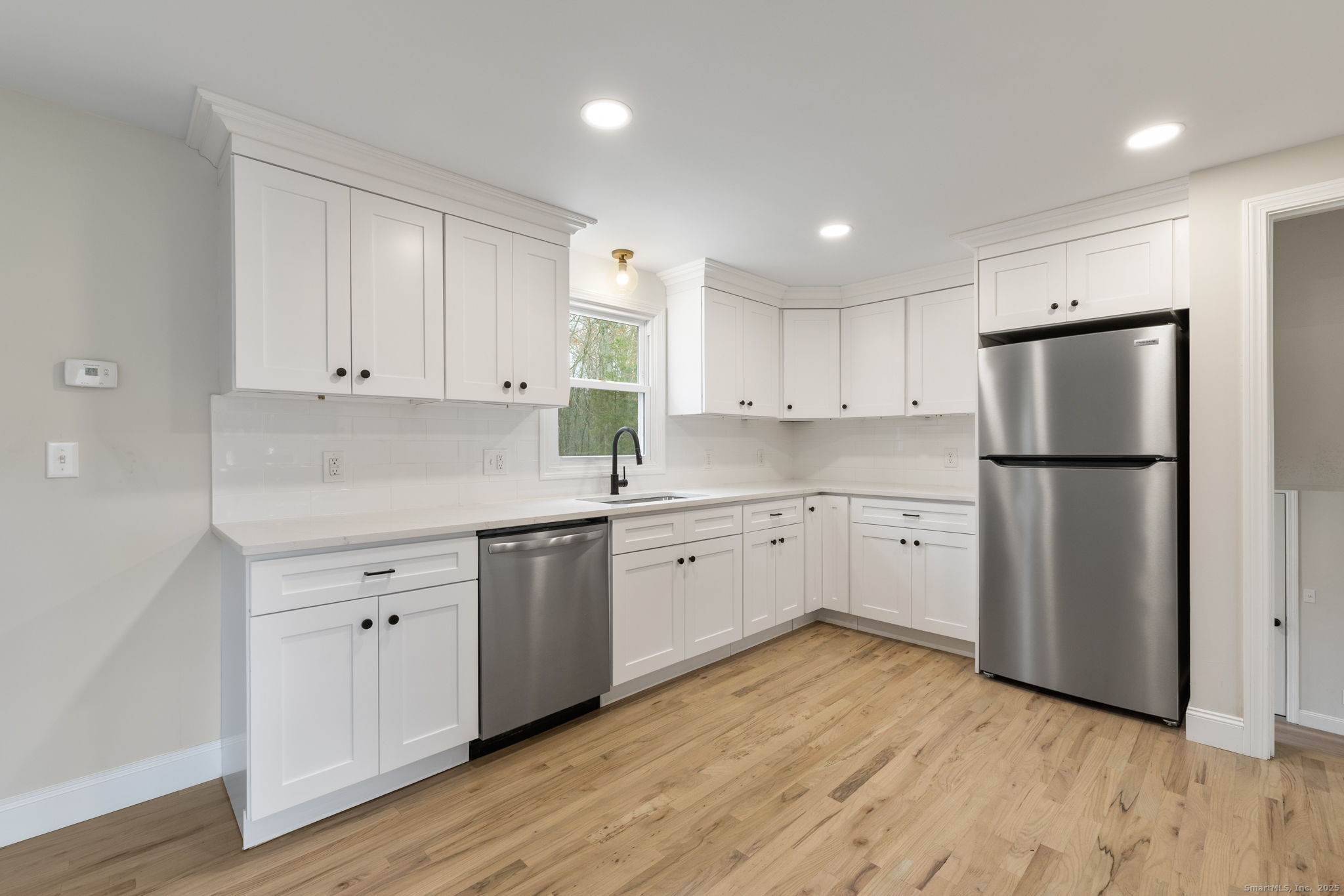 410 South Stone Street Suffield, CT 06093 - Photo 6 of 23 a kitchen with white cabinets and white appliances