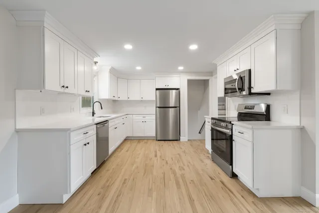 a kitchen with white cabinets and stainless steel appliances