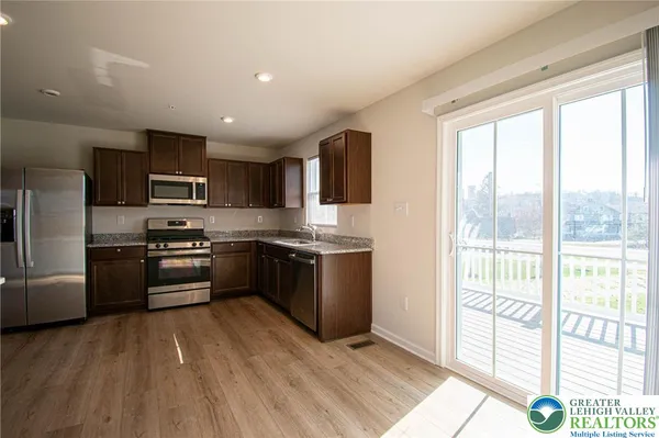 a kitchen with granite countertop a refrigerator stove top oven and sink