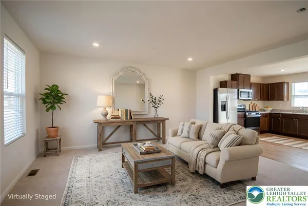 a living room with furniture a large window and a potted plant