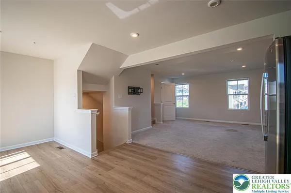 a view of empty room with window and wooden floor