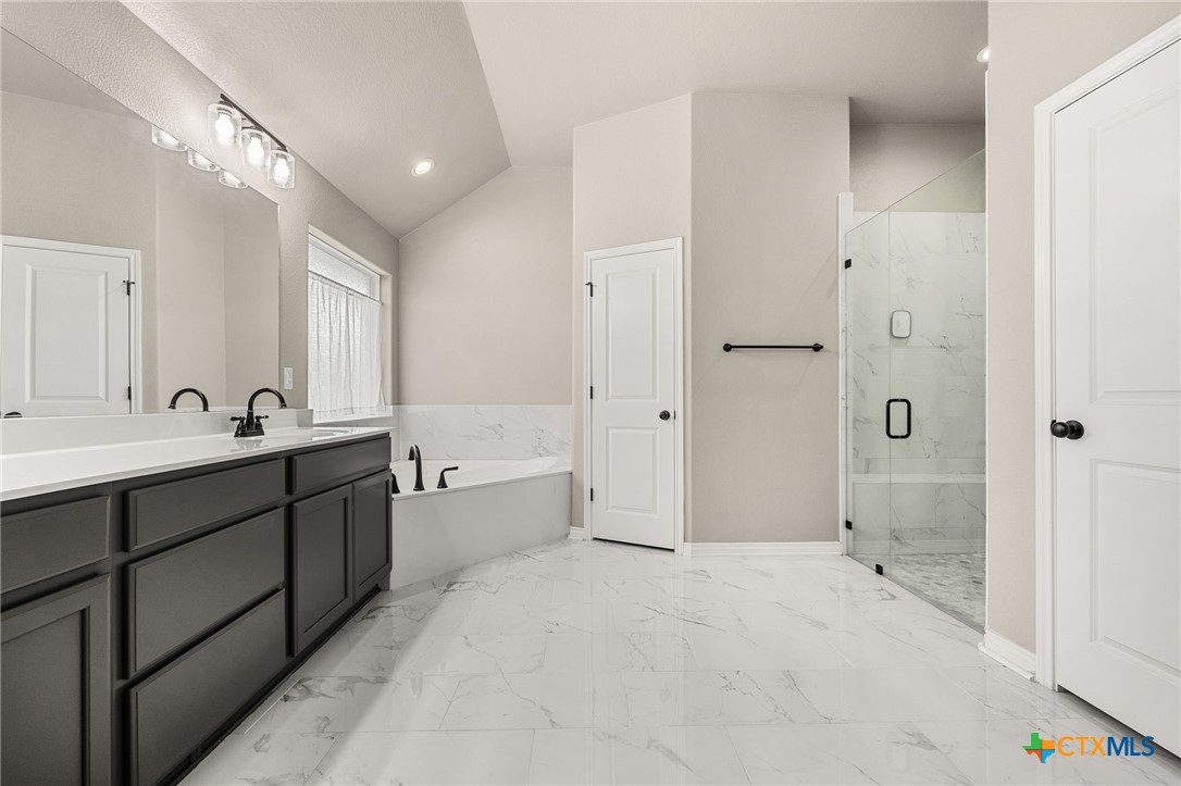 223 Sand Flat Lane Temple, TX 76502 - Photo 18 of 33 a spacious bathroom with a tub sink shower and mirror