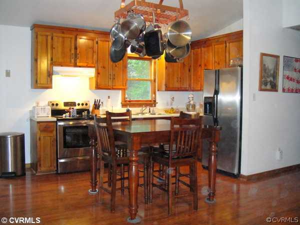 466 Signboard Road Bumpass, VA 23024 - Photo 8 of 12 a kitchen with stainless steel appliances a table chairs and a window