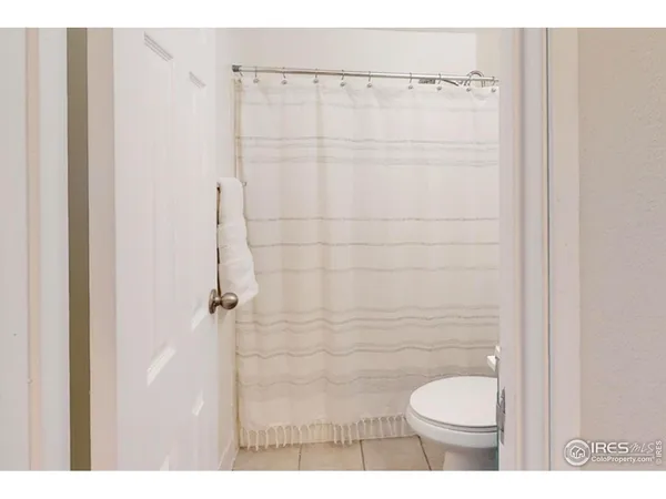 a bathroom with a toilet and a shower curtain