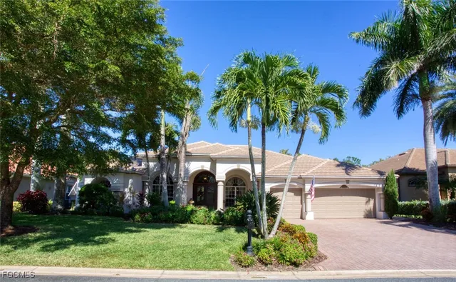 a front view of a house with garden and palm trees