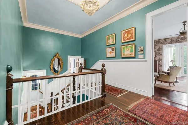 a view of a hallway with workspace and wooden floor