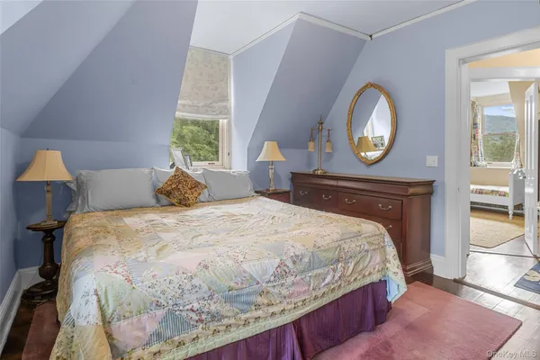 a bedroom with a bed and a mirror on dresser