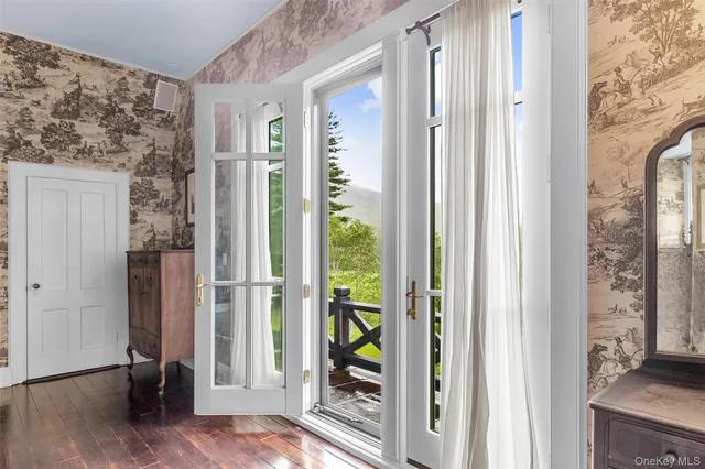 a view of a hallway with wooden floor and a living room